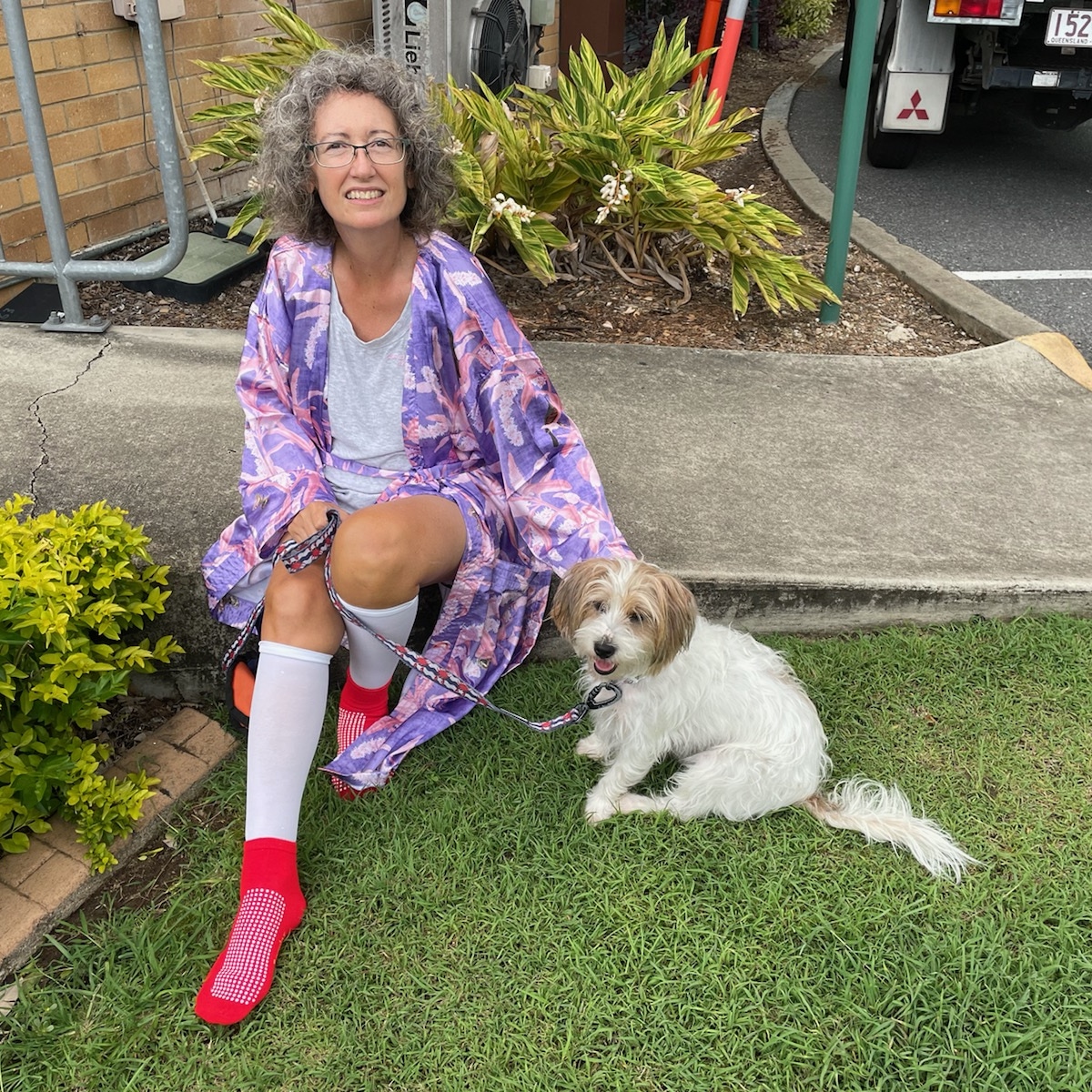 Judi, sitting with her dog on the grass