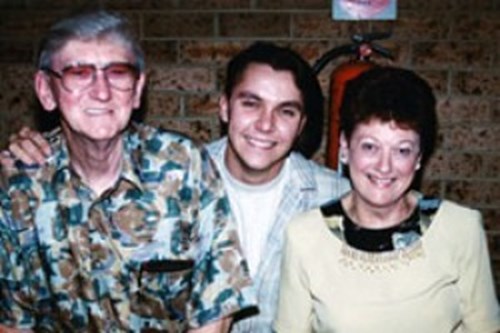 Kate with her husband and son smiling. 