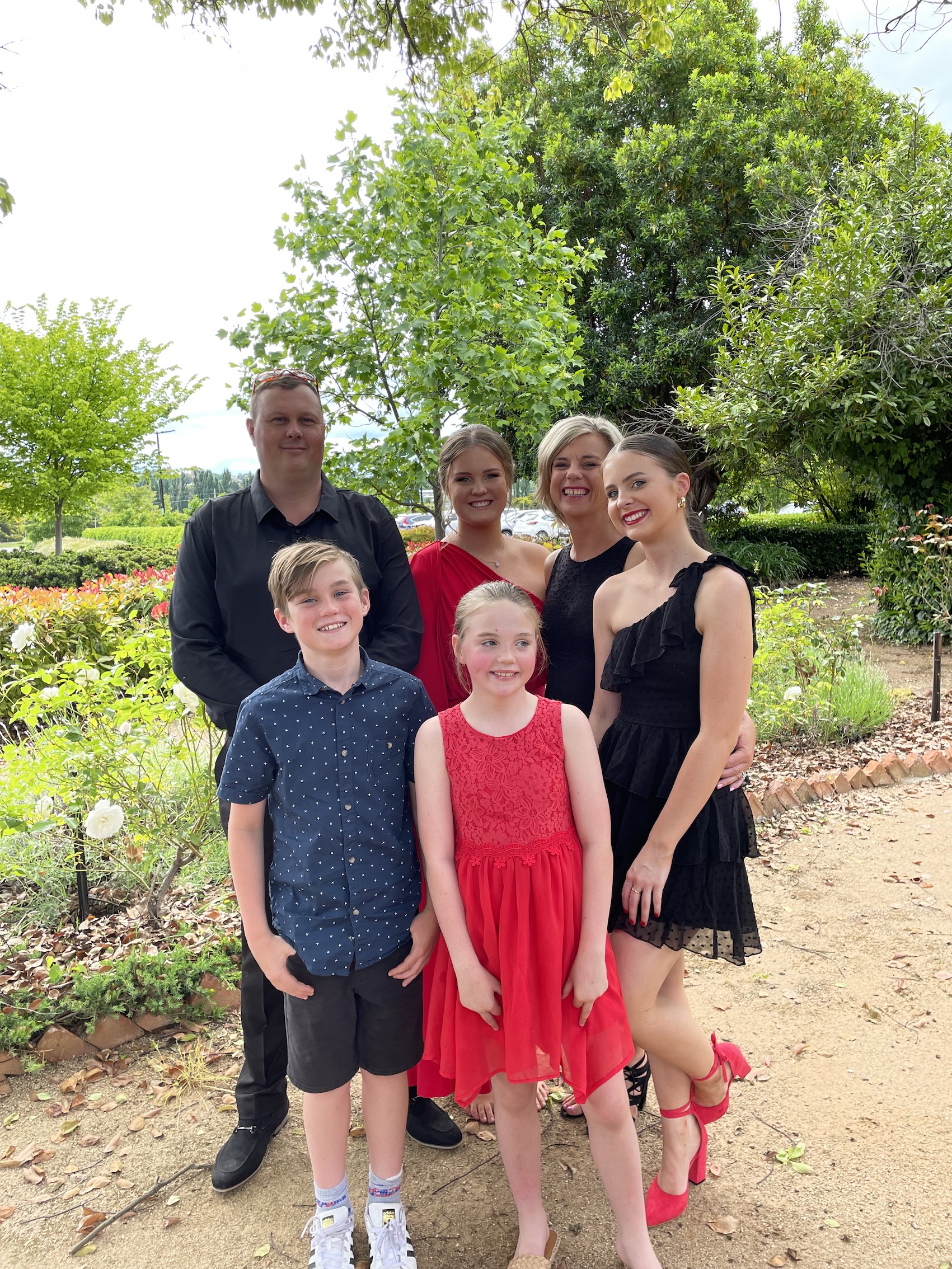 Melissa standing with her family in a garden. 