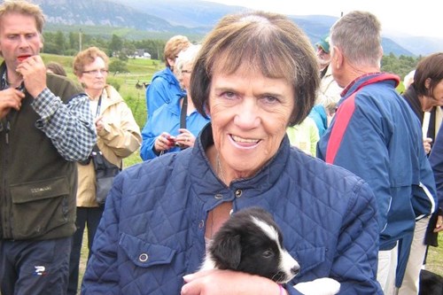 Louis holding a puppy smiling. 